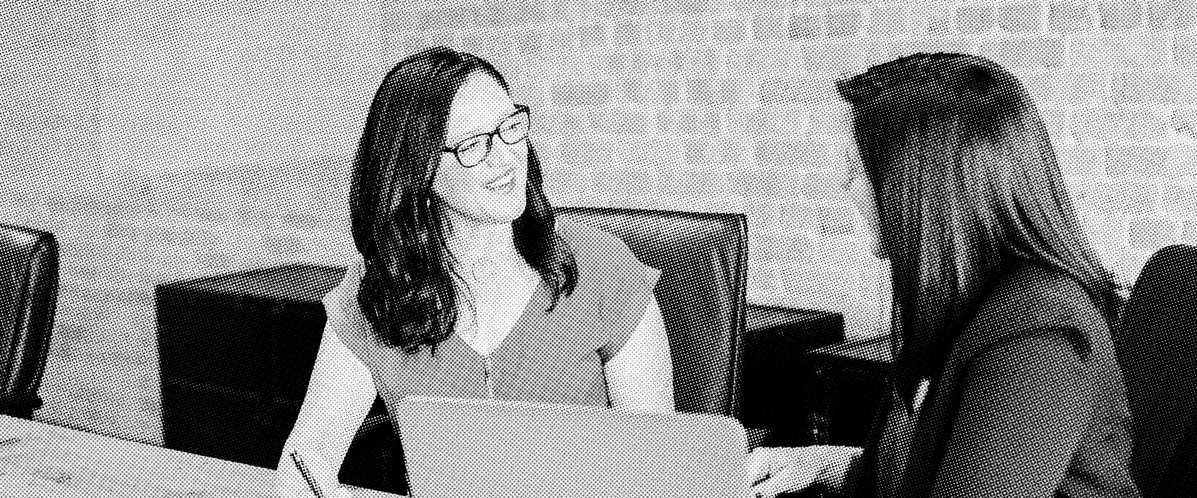 Two professionals discussing a project in a meeting room, representing the key factors that influence web development timelines, project scope, and delivery schedules.
