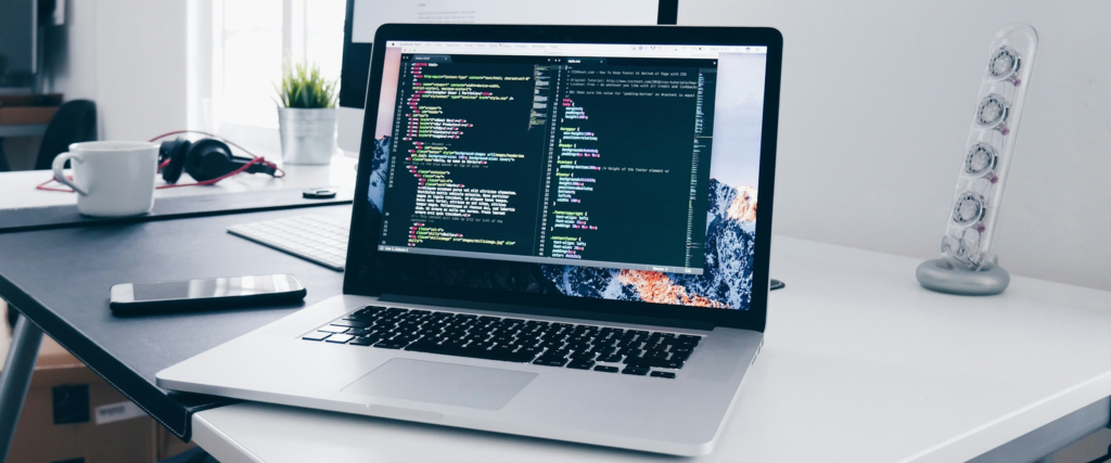 Laptop displaying website code for a web development project