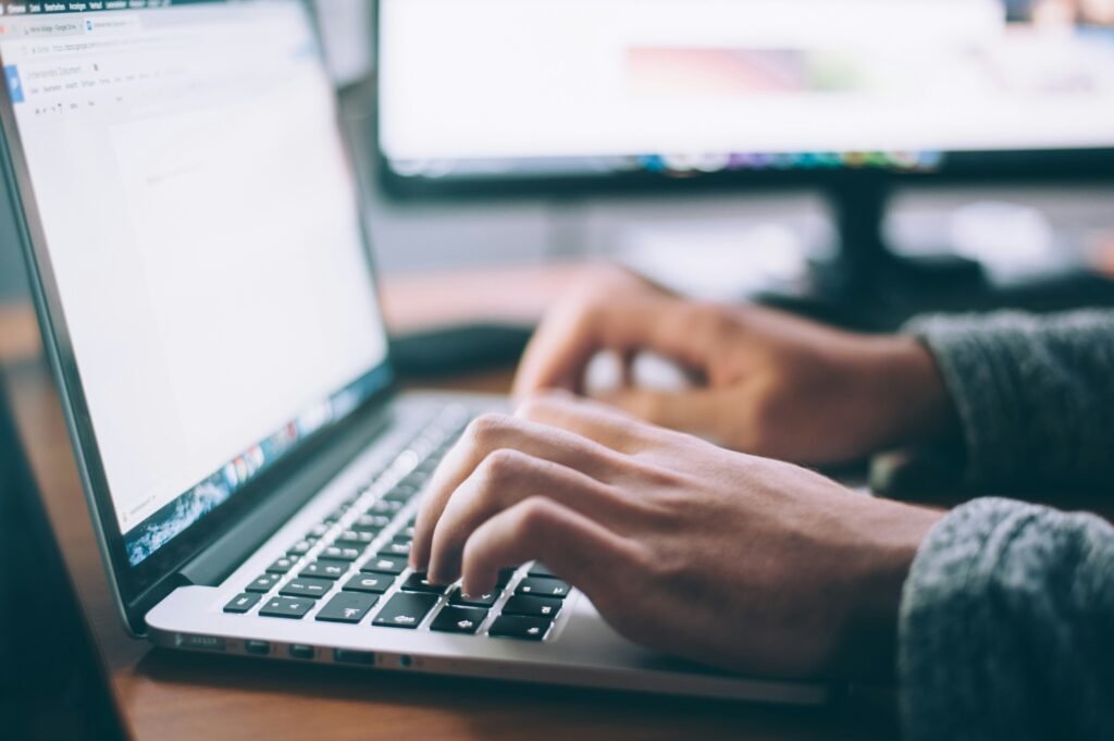 Entrepreneur researching e-commerce website costs on a laptop